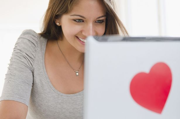 Woman-Using-Laptop-With-Heart-shaped-Sticker